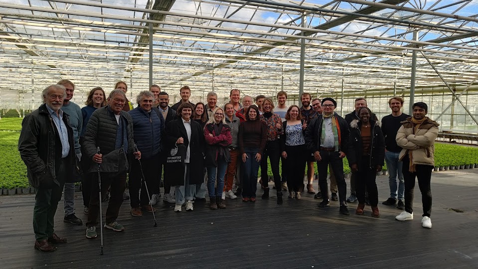 A group of people standing in a greenhouse
AI-generated content may be incorrect.